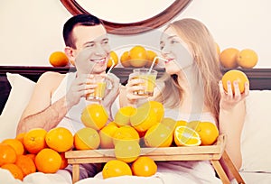 Young cheerful smiling couple with ripe oranges