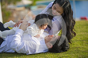 Young cheerful and sweet wife and husband couple with mother and father playing with little daughter in Asian Chinese family