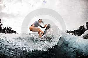 Young cheerful woman is engaged in wake surfing