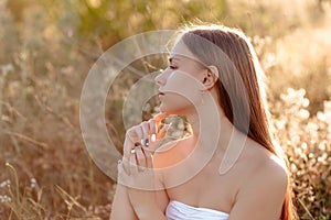 Young cheerful woman in a park enjoying sunset