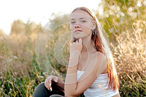 Young cheerful woman in a park enjoying sunset