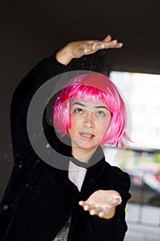 Young cheerful woman in a pink wig