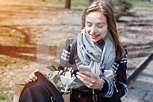 Young cheerful woman posing while photographing herself on smart phone camera for a chat with friends, attractive