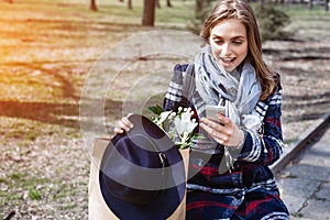 Young cheerful woman posing while photographing herself on smart phone camera for a chat with friends, attractive