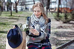 Young cheerful woman posing while photographing herself on smart phone camera for a chat with friends, attractive