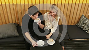 Young cheerful woman talking via cell phone, while dating in the coffee shop