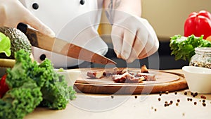 Young chef is cutting octopus in a modern kitchen. The man prepares food at home. Cooking healthy food.