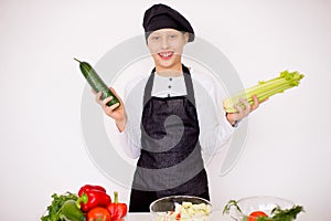 Young chef holding vegetables isolate