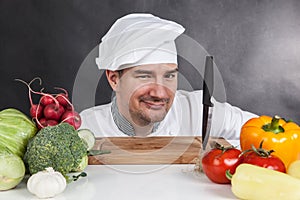 Young chef with knife and vegetable