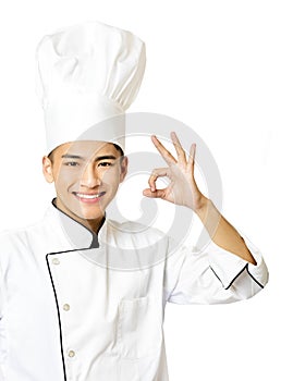 Young chef with ok gesture on white