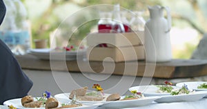 Young chef is putting bread on a plate, presentation of a dish, close up, 4k