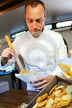 Young chef serving barbecue potatoes in a food truck.