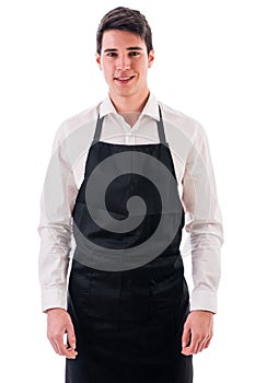 Young chef or waiter wearing black apron isolated