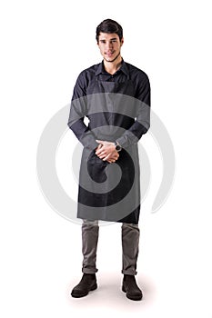 Young chef or waiter wearing black apron isolated