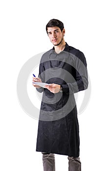 Young chef or waiter wearing black apron isolated