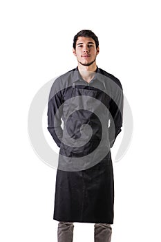 Young chef or waiter wearing black apron isolated