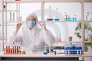 Young male chemist in drugs syntesis concept photo