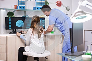 Young chemist man working in a laboratory with a female microbiologist