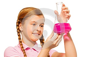 Young chemist pouring pink reagent in glass retort