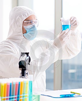 Young chemist student working in lab on chemicals