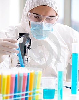 Young chemist student working in lab on chemicals