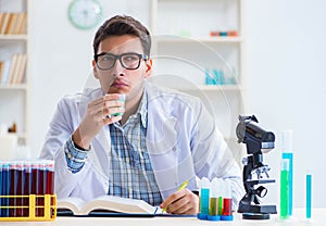 Young chemist student working in lab on chemicals