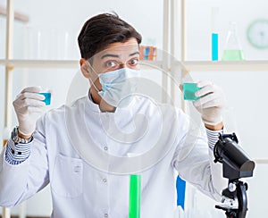 Young chemist student working in lab on chemicals