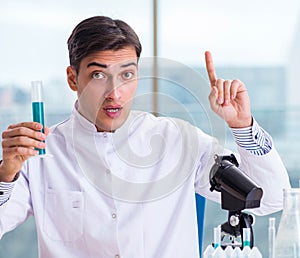 Young chemist student working in lab on chemicals