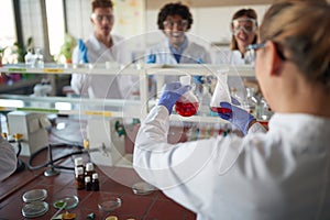 Young chemistry students are amazed by chemical reaction in an experiment they doing in a laboratory. Science, chemistry, lab,