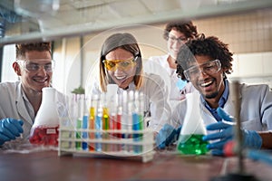 Young chemistry students having a good time in a laboratory while enjoying observing colorful chemical reactions. Science,