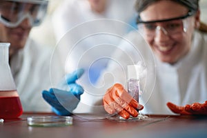 Young chemistry students in a protective gear enjoy watching dangerous chemical reaction in the university laboratory. Science,