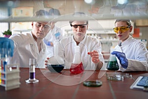 Young chemistry students work with caution while handling dangerous chemicals in the university laboratory. Science, chemistry,