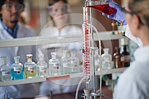 Young chemistry students are working with caution with chemical apparatus in a laboratory. Science, chemistry, lab, people