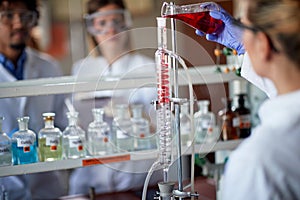 Young chemistry students are working with chemical apparatus in a laboratory. Science, chemistry, lab, people
