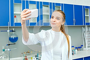 Young chemistry teacher in school laboratory work standing selfie