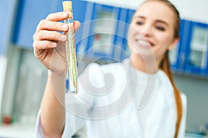 Young chemistry teacher in school laboratory work test-tube with wheat