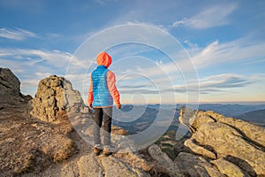 Young child boy hiker standing in mountains enjoying view of amazing mountain landscape