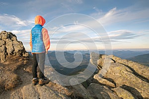 Young child boy hiker standing in mountains enjoying view of amazing mountain landscape