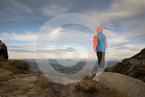 Young child boy hiker standing in mountains enjoying view of amazing mountain landscape