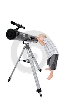 Young child or boy looking through a telescope