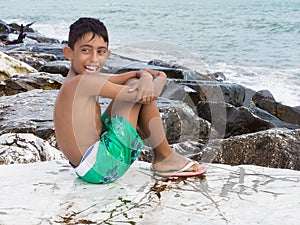 Young child boy sitting on rocks