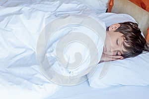 Young child boy sleeping in bed at home,