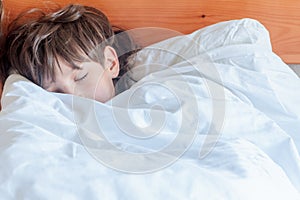 Young child boy sleeping in bed at home,