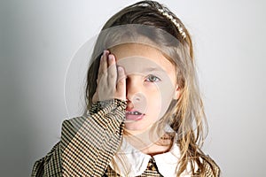 young child covering face and hand eye having eye exam. Testing a child\'s eyes.