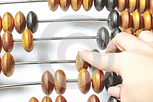 Young child delicately touching the beads of an abacus, counting and learning mathematics