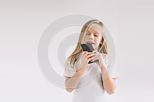 Young child eating a chocolate bar. Blondy girl isolated on white background.