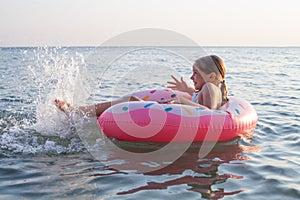 Young child girl laughing and playing in water at the seaside