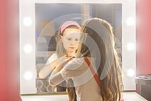 Young child girl making a hair style as a hairdresser