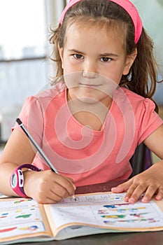 Young child girl writing in notebook