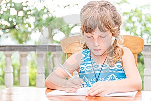 young child girl writing in notebook, outdoors portrait, education idea
